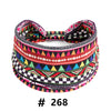A colorful patterned fabric headband featuring geometric designs in pink, black, green, and red.