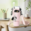 A pink neoprene water bottle carrier bag with a shoulder strap and various keys is displayed on a wooden table.