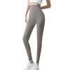 Une femme portant des leggings en peau de requin gris d'été et un haut blanc.