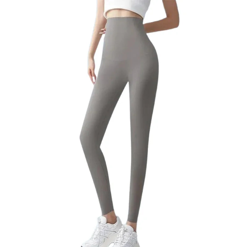 Une femme portant des leggings en peau de requin gris d'été et un haut blanc.