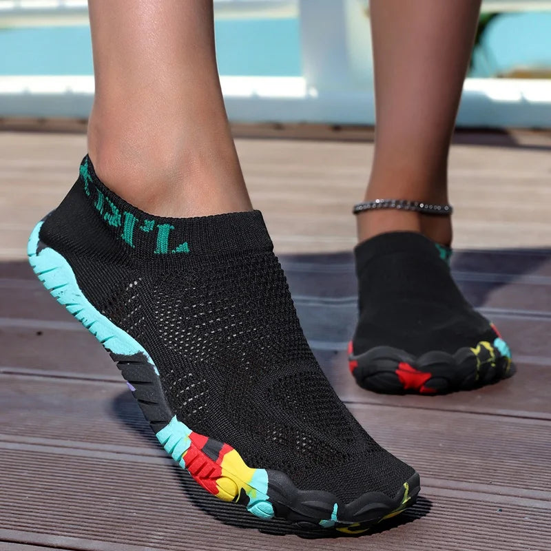 A pair of black waterproof quick-dry outdoor hiking shoes with colorful accents resting on a wooden deck.