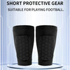A pair of black honeycomb shin guards displayed on a clear stand for football training.