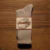 A pair of gray thick cotton tube socks featuring a quality label with the word Quality.