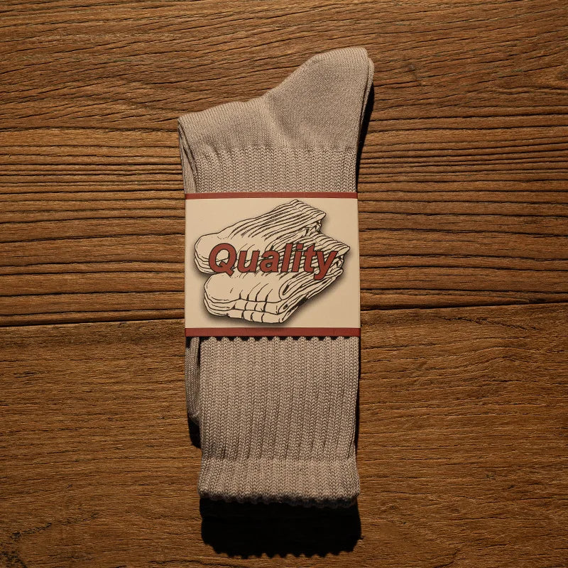 A pair of gray thick cotton tube socks featuring a quality label with the word Quality.