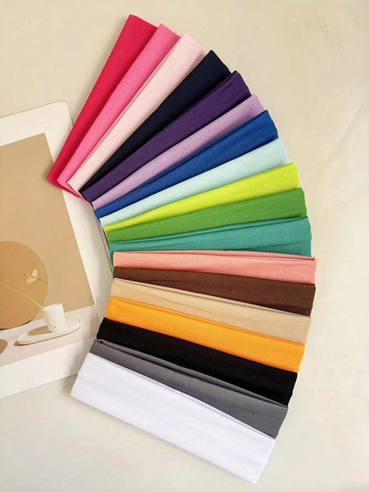 A stack of colorful anti-slip elastic headbands in various shades of pink, purple, blue, green, and yellow.