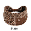 A brown boho print cotton headband with white embroidery, shown flat.