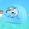 A light blue swimming cap featuring a cartoon whale design swimming in water.