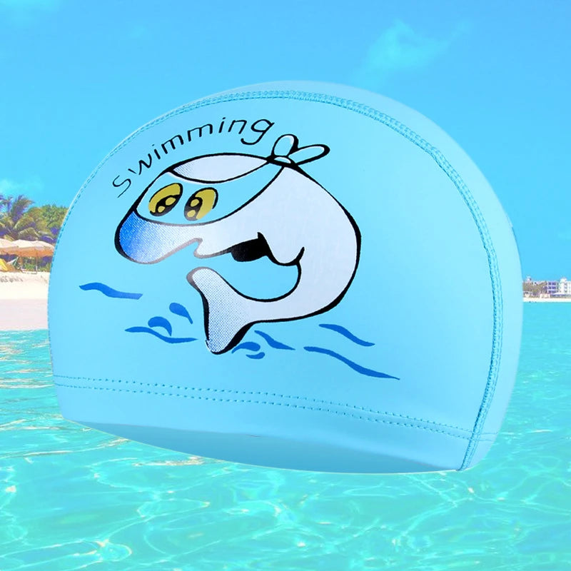 A light blue swimming cap featuring a cartoon whale design swimming in water.