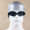 A silver waterproof swim cap is placed on a white mannequin head, featuring dark tinted goggles.