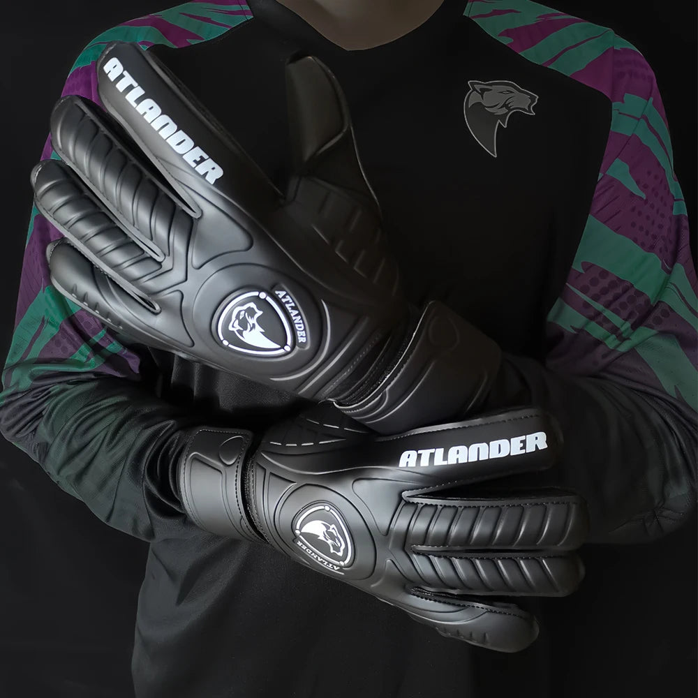 Black leather goalkeeper gloves with the Atlander logo worn by a person.