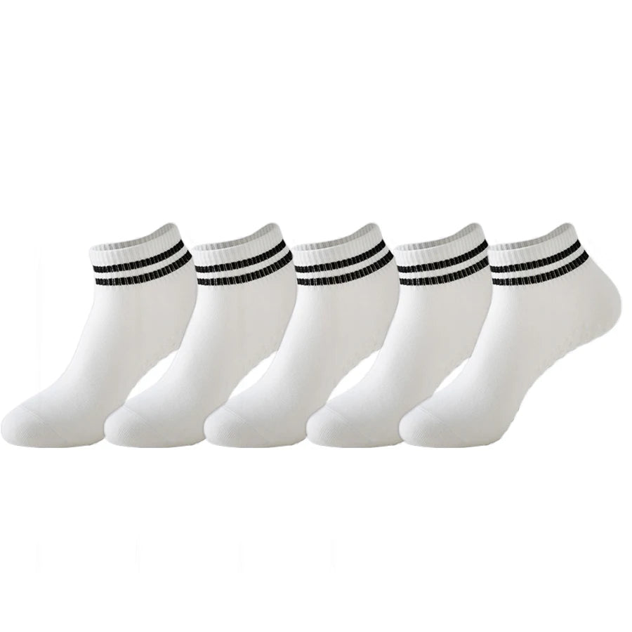 A set of white non-slip grip socks with black stripes for yoga and pilates