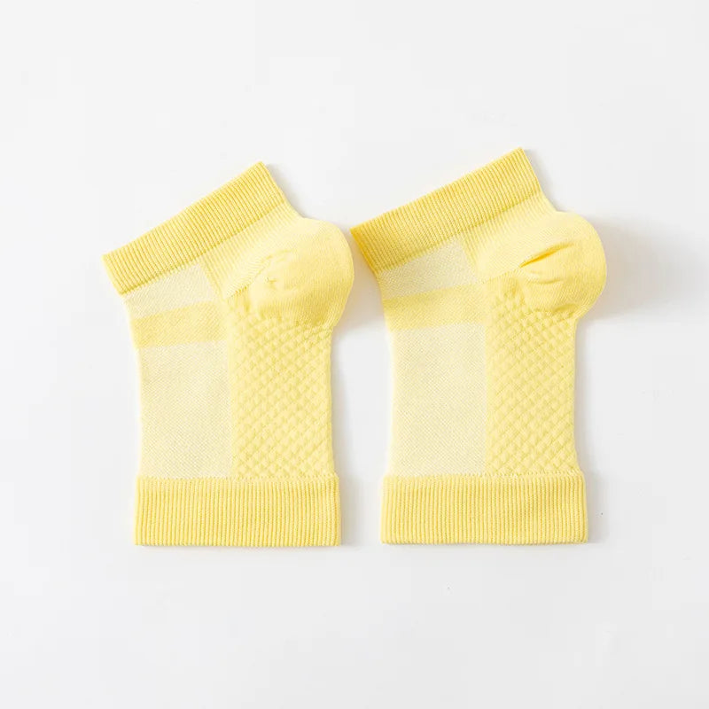 A pair of yellow therapeutic compression socks for foot and ankle pain relief.