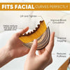 A hand holds a yellow facial brush designed to lift, tighten, and improve blood circulation on the face.
