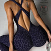 A woman wearing a dark purple leopard print seamless yoga jumpsuit, shown from the back.