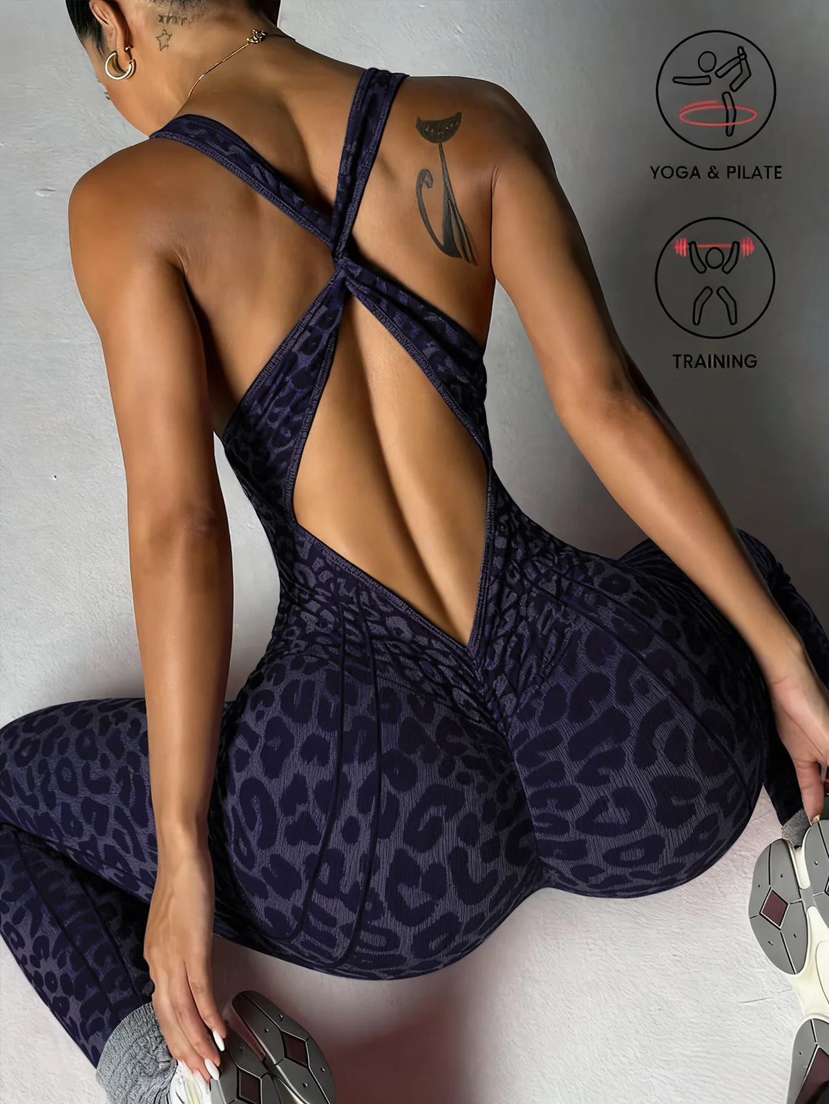 A woman wearing a dark purple leopard print seamless yoga jumpsuit, shown from the back.