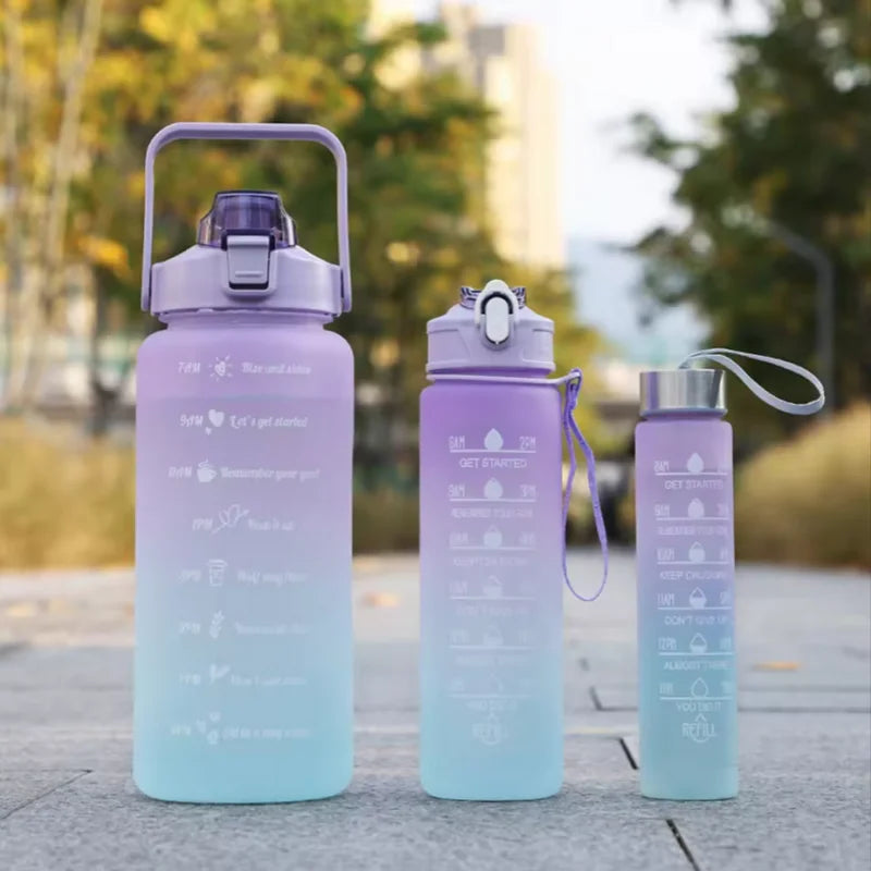A light purple sports water bottle with a straw and various motivational text is shown on a gray surface.