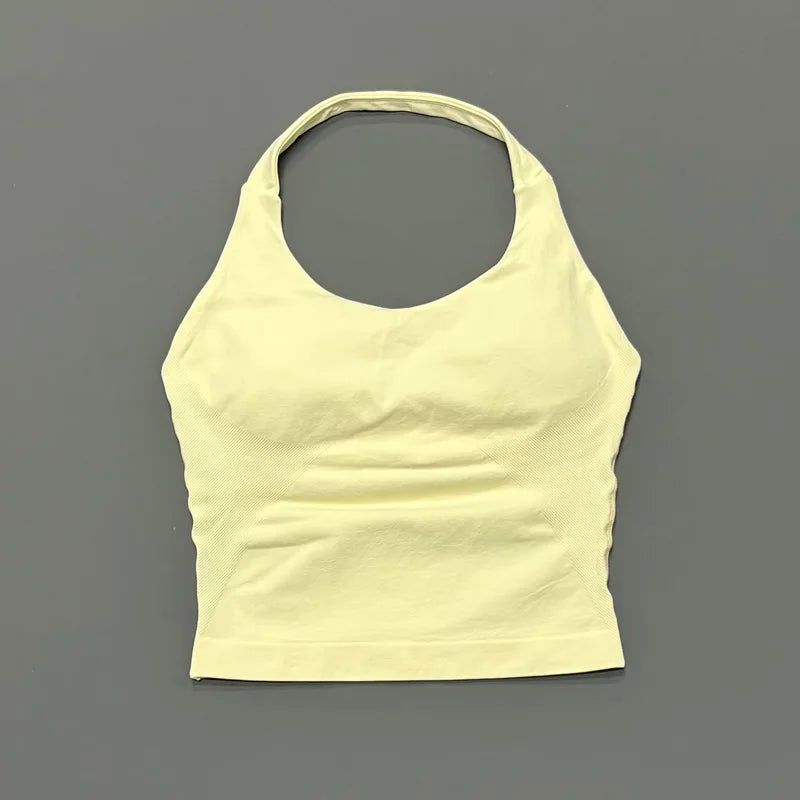 A light yellow seamless performance yoga and gym tank top displayed against a gray background.