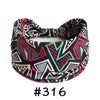 A black patterned boho knotted cotton headband with pink, green, and white geometric designs.