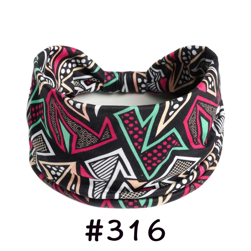 A black patterned boho knotted cotton headband with pink, green, and white geometric designs.