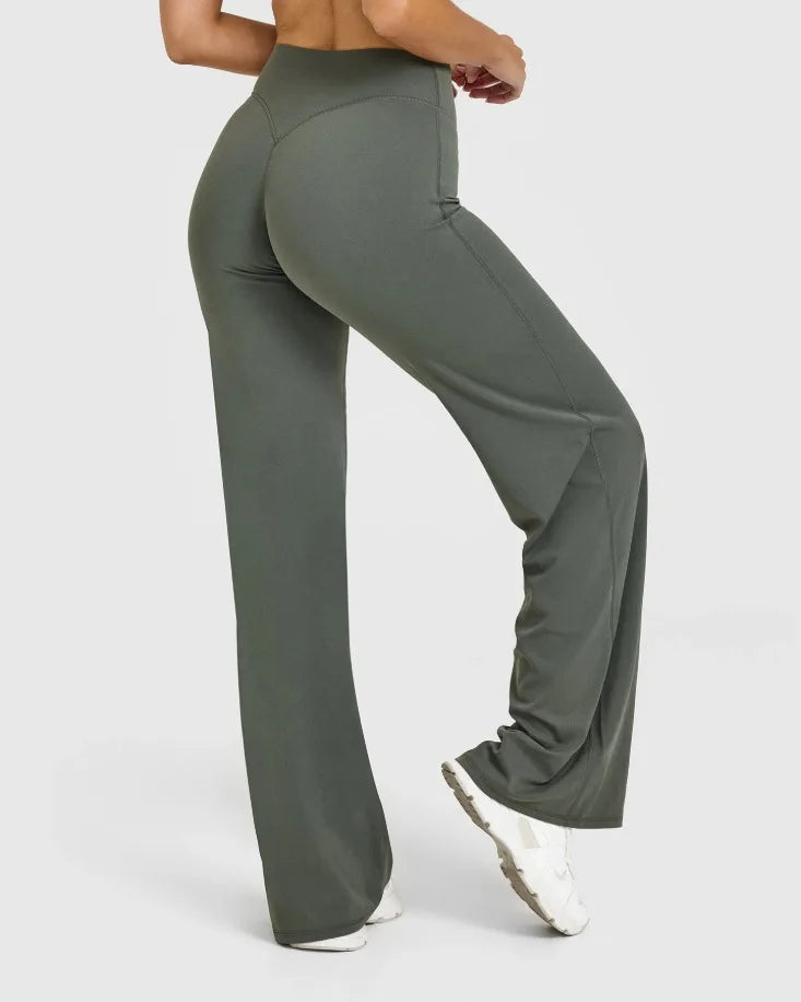 A person is modeling high-waist olive green yoga pants with a white top.