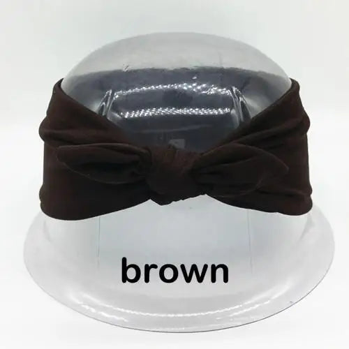 Braunes Hasenohr-Headband auf einem klaren Ständer.