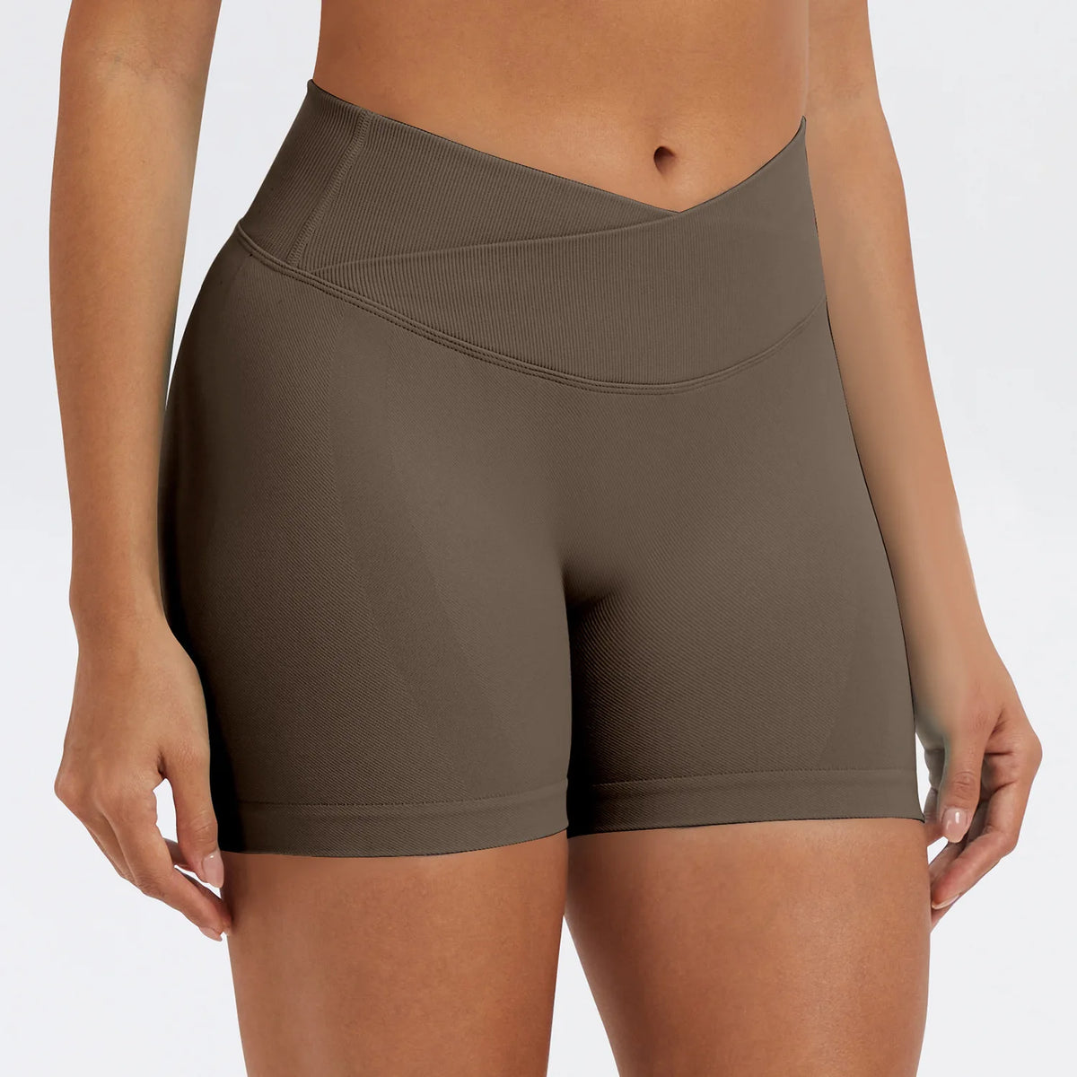 A model wearing seamless high-waist yoga leggings in a taupe brown color.