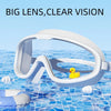 Gafas de natación blancas antiempañantes con lente grande flotando en agua azul con un pato amarillo.