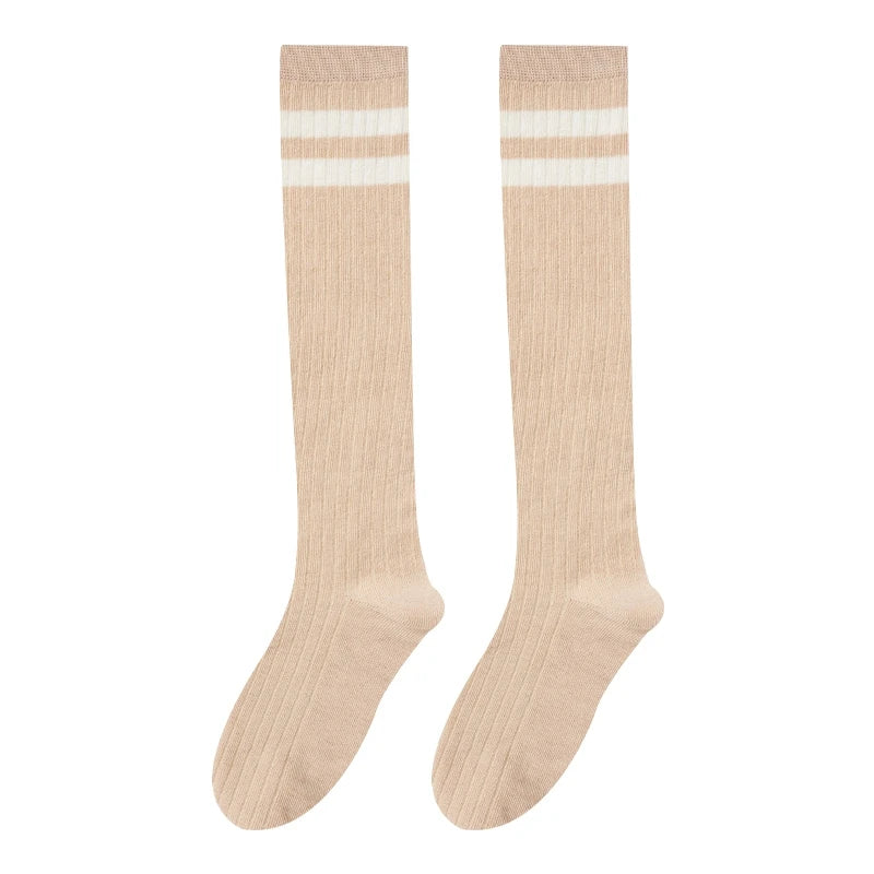 A pair of beige striped cotton knee high socks with a ribbed texture.