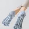 Light blue five-finger yoga socks worn on a person's foot and ankle.