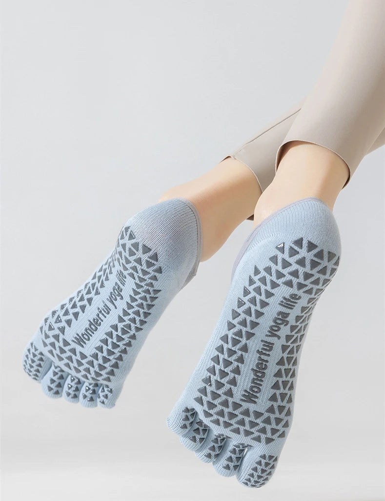 Light blue five-finger yoga socks worn on a person's foot and ankle.