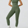 Model trägt ein zweteiliges Yoga-Set aus salbeigrünem High-Waist-Top und passenden Leggings.