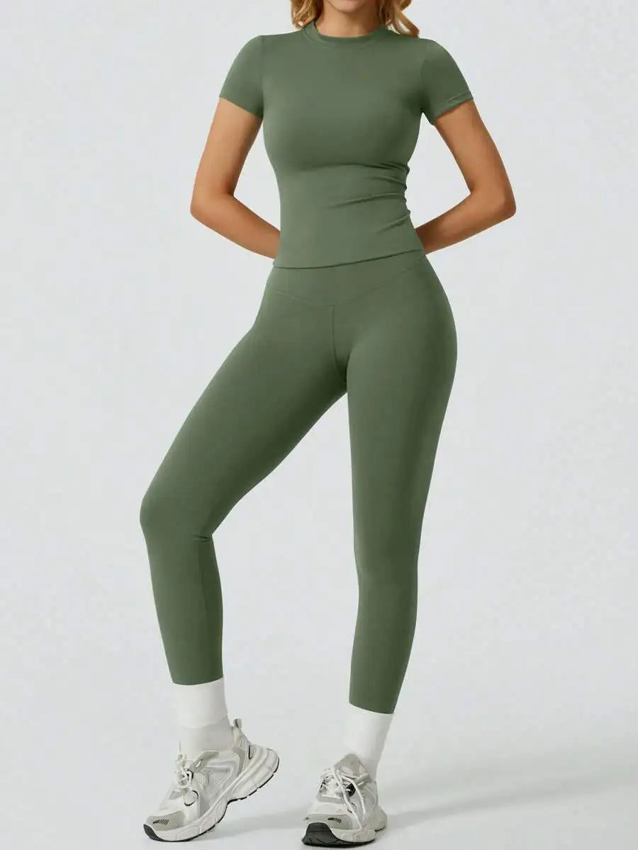 Model trägt ein zweteiliges Yoga-Set aus salbeigrünem High-Waist-Top und passenden Leggings.
