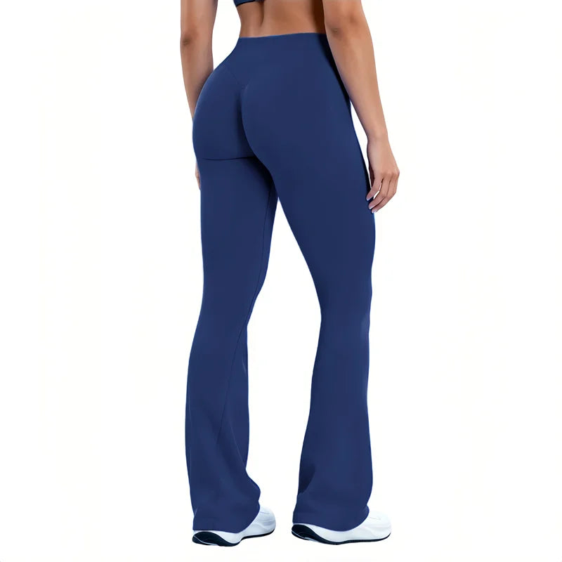 A woman wearing dark blue seamless flared yoga leggings and white athletic shoes.