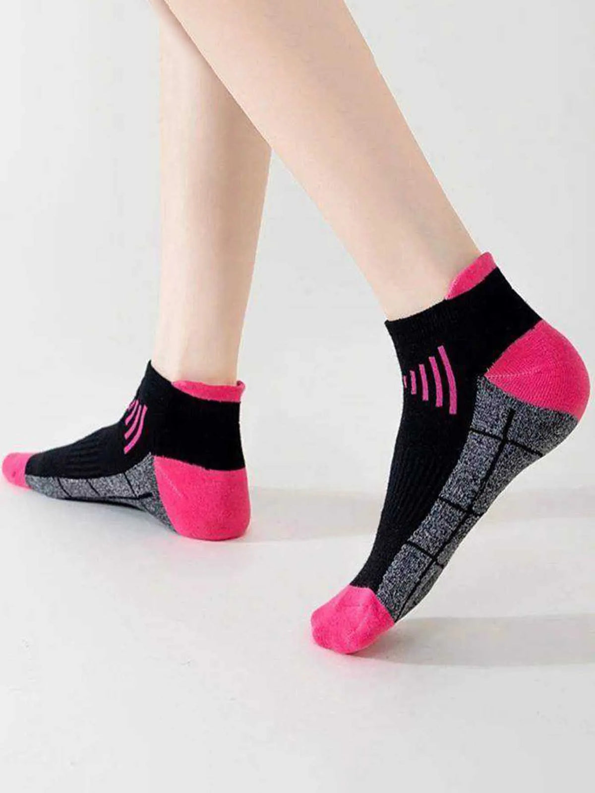 Ein Paar sportliche Funktionssocken für Damen in Schwarz und Pink mit strukturiertem Muster