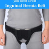 A black inguinal hernia belt worn around the waist of a person wearing gray clothing.