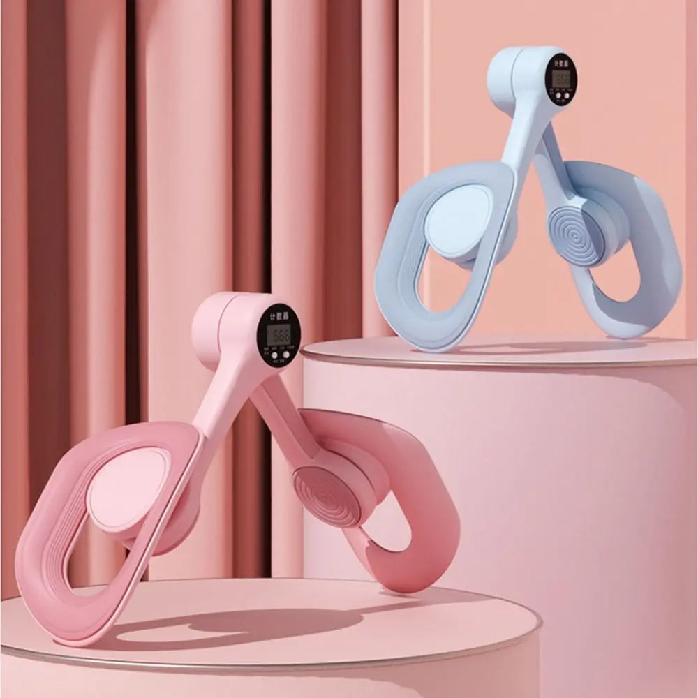 Two light pink and blue thigh and hip strength trainers are displayed on a pink pedestal.