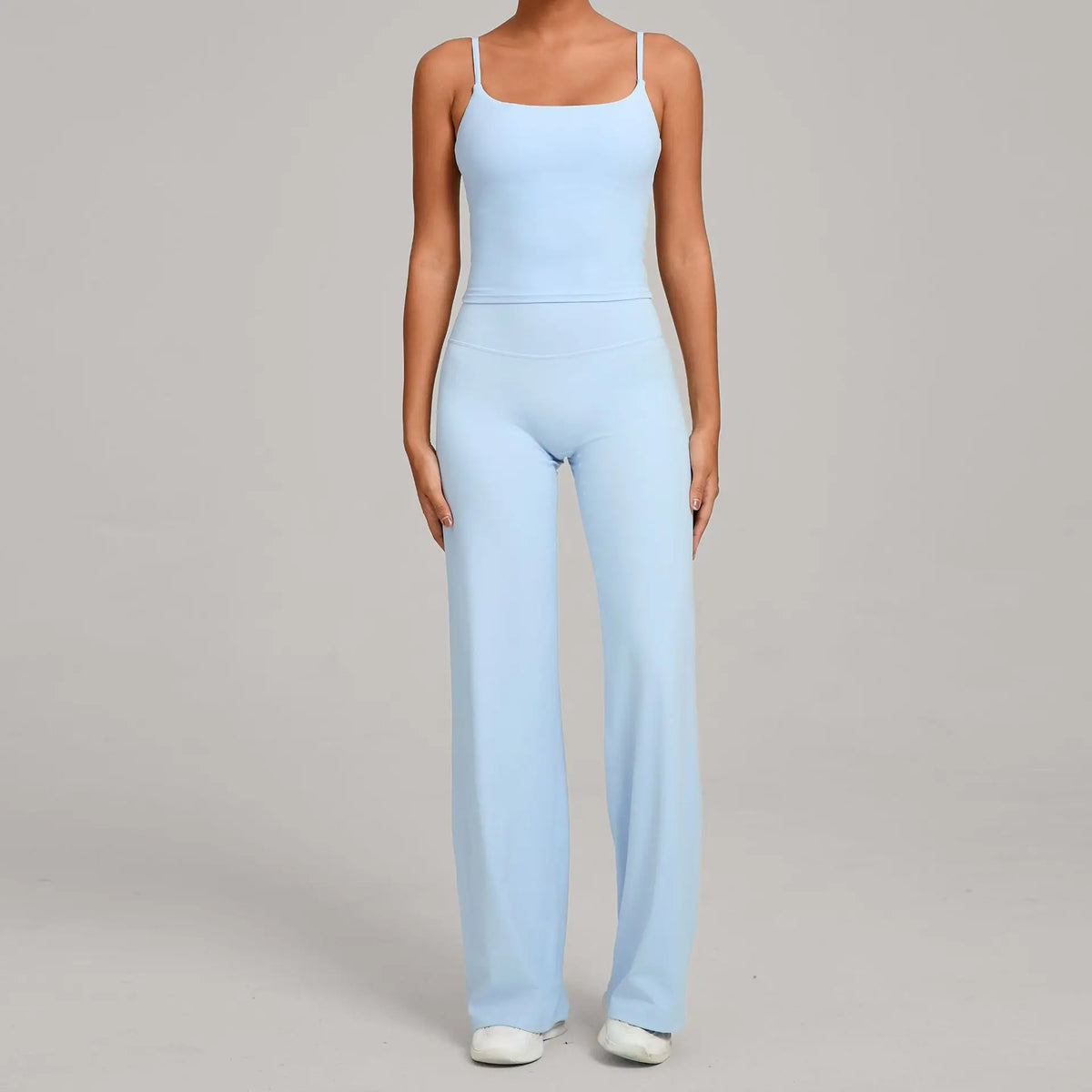 A woman wearing a light blue high-waist yoga and fitness tracksuit set.