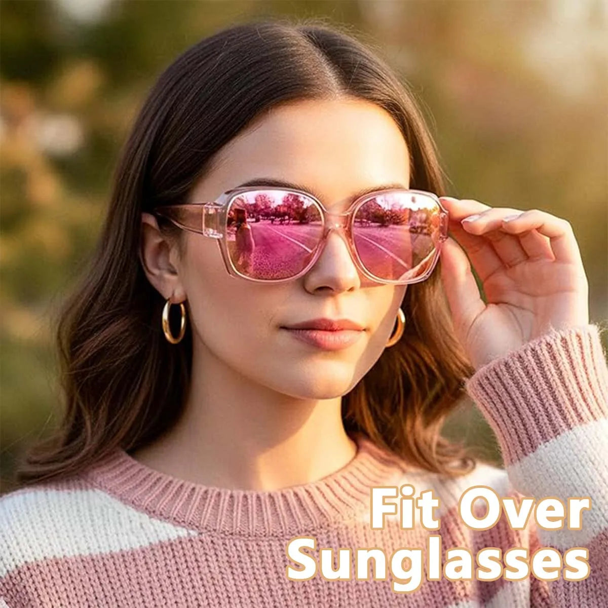 A woman models pink-tinted wrap-around sunglasses with glasses compatibility against a blurred outdoor background.