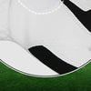 A close-up view of a breathable microfiber golf and sports glove with black and white patterns on a green golf course.