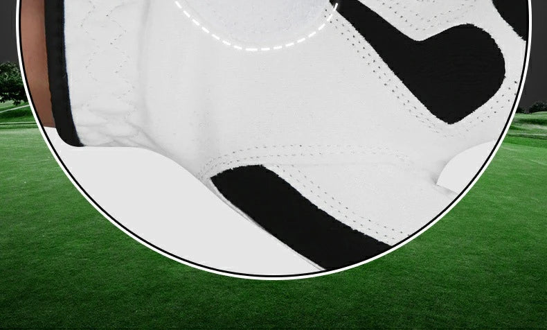 A close-up view of a breathable microfiber golf and sports glove with black and white patterns on a green golf course.
