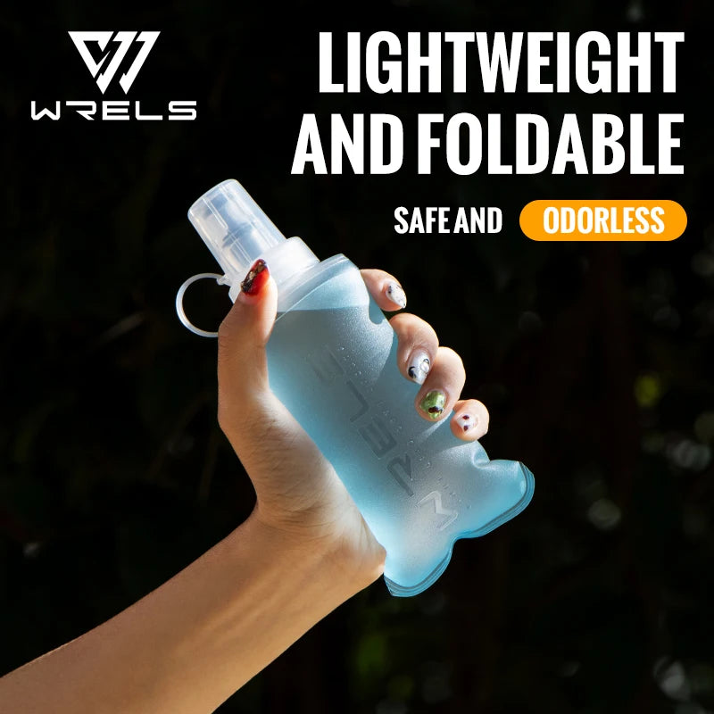 A hand holds a clear silicone water flask with a pump dispenser outdoors.