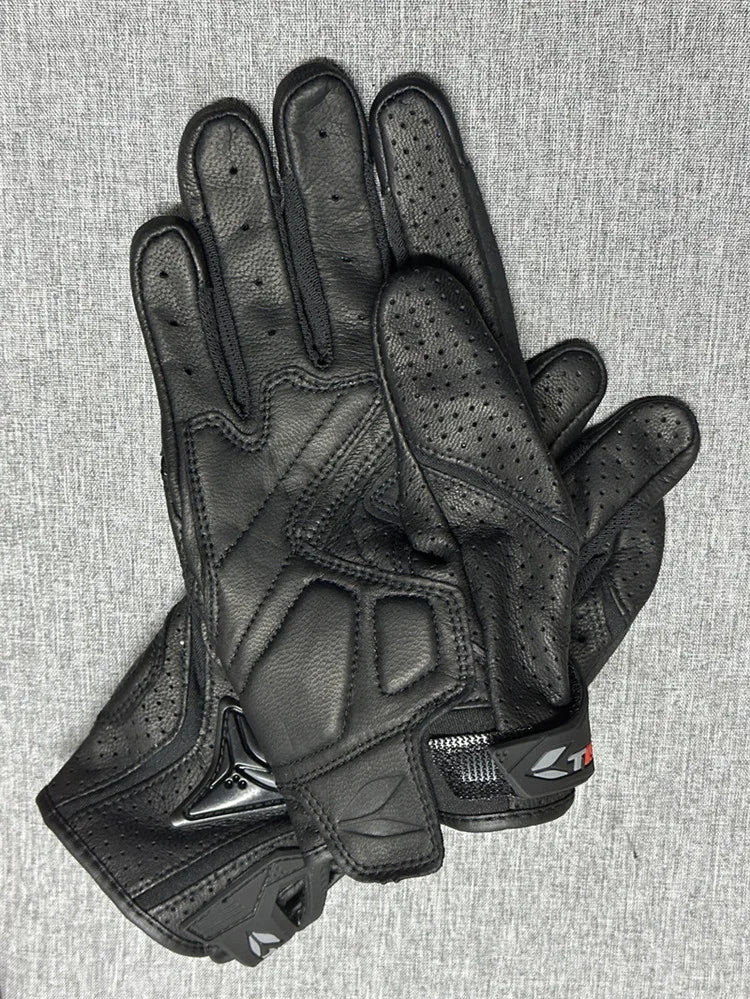 A pair of black genuine leather motorcycle motocross gloves shown against a gray background.