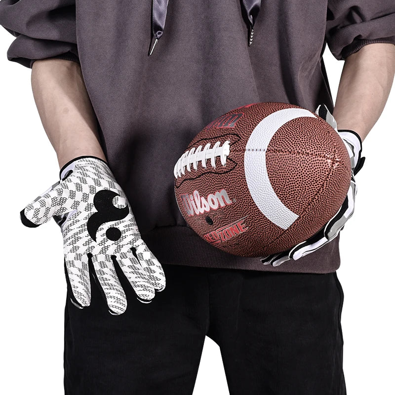 Une personne portant un sweat gris tient un ballon de basketball marron et un gant de sport en silicone blanc.