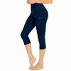 Leggings de yoga capri de cintura alta azul marino oscuro con bolsillos laterales mostrados en una modelo.