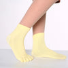 Yellow yoga socks with a textured knit pattern worn on a foot.