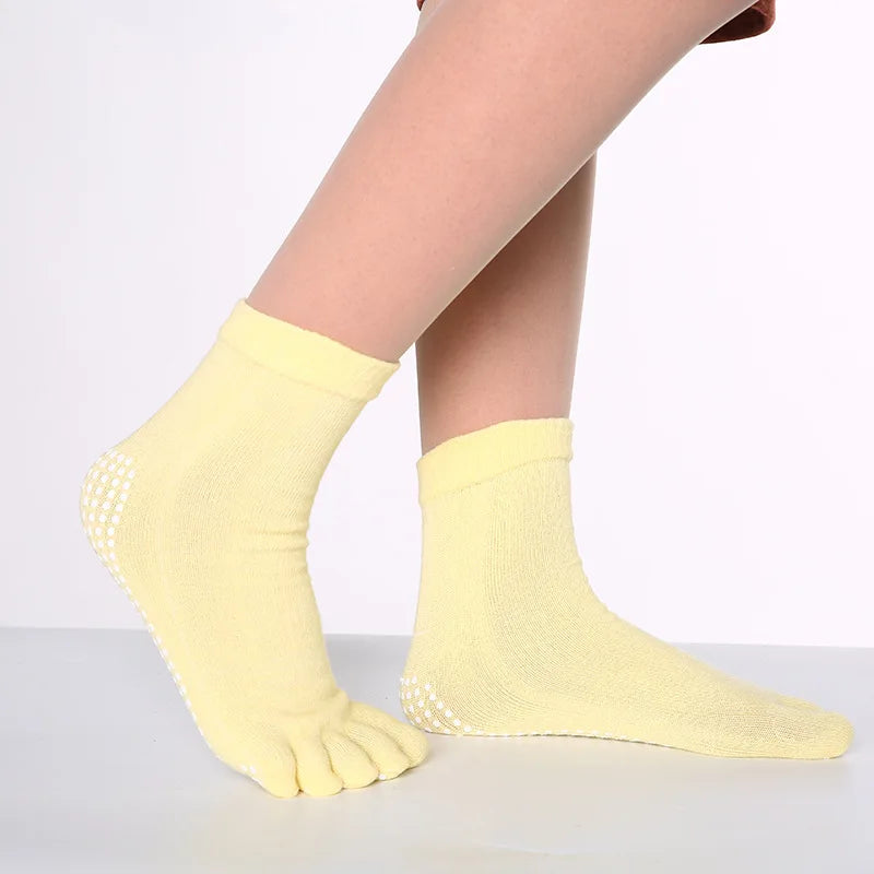 Yellow yoga socks with a textured knit pattern worn on a foot.