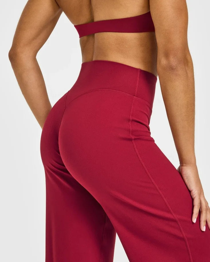 A model wearing red high-waist yoga pants, showing the fit and fabric.