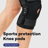 Black sports knee pads with spring support and binding tape shown on a person's leg.