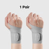 A pair of gray breathable wrist compression braces shown on a person's hands and wrists.