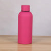 A pink double-layer vacuum thermos cup standing upright on a wooden surface.